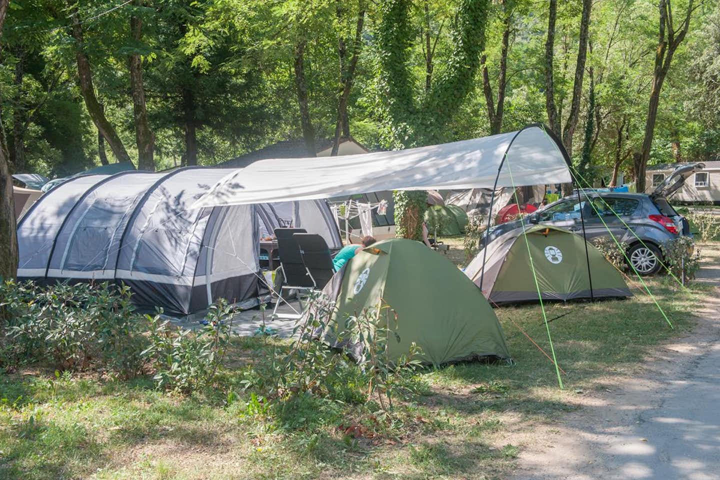Camping Les Plans  -  Wohnwagen- und Zeltstellplatz unter Bäumen auf dem Campingplatz