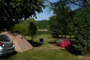 Camping Les Reflets du Lac - Zeltplatz im Schatten der Bäume mit Blick auf den See auf dem Campingplatz