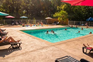 Camping les rives du lac - Pool im Freien mit Liegestühlen und Sonnenschirmen