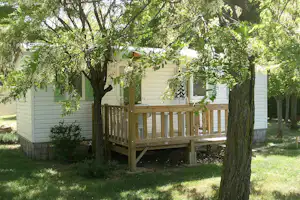 Camping Les Roches - Mobilheim zwischen Bäumen auf dem Campingplatz