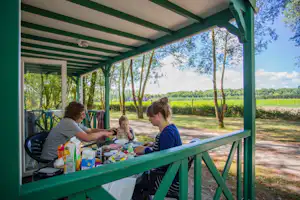 Camping Les Saules - Camper auf der Veranda vom Mobilheim auf dem Campingplatz im Grünen