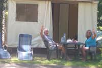 Camping Les Sources - Camper sitzen vor dem Vorzelt ihres Wohnwagens