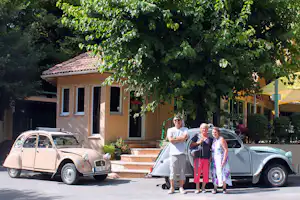 Camping Les Sources - Camper stehen vor Oldtimern vor dem Restaurant des Campingplatzes