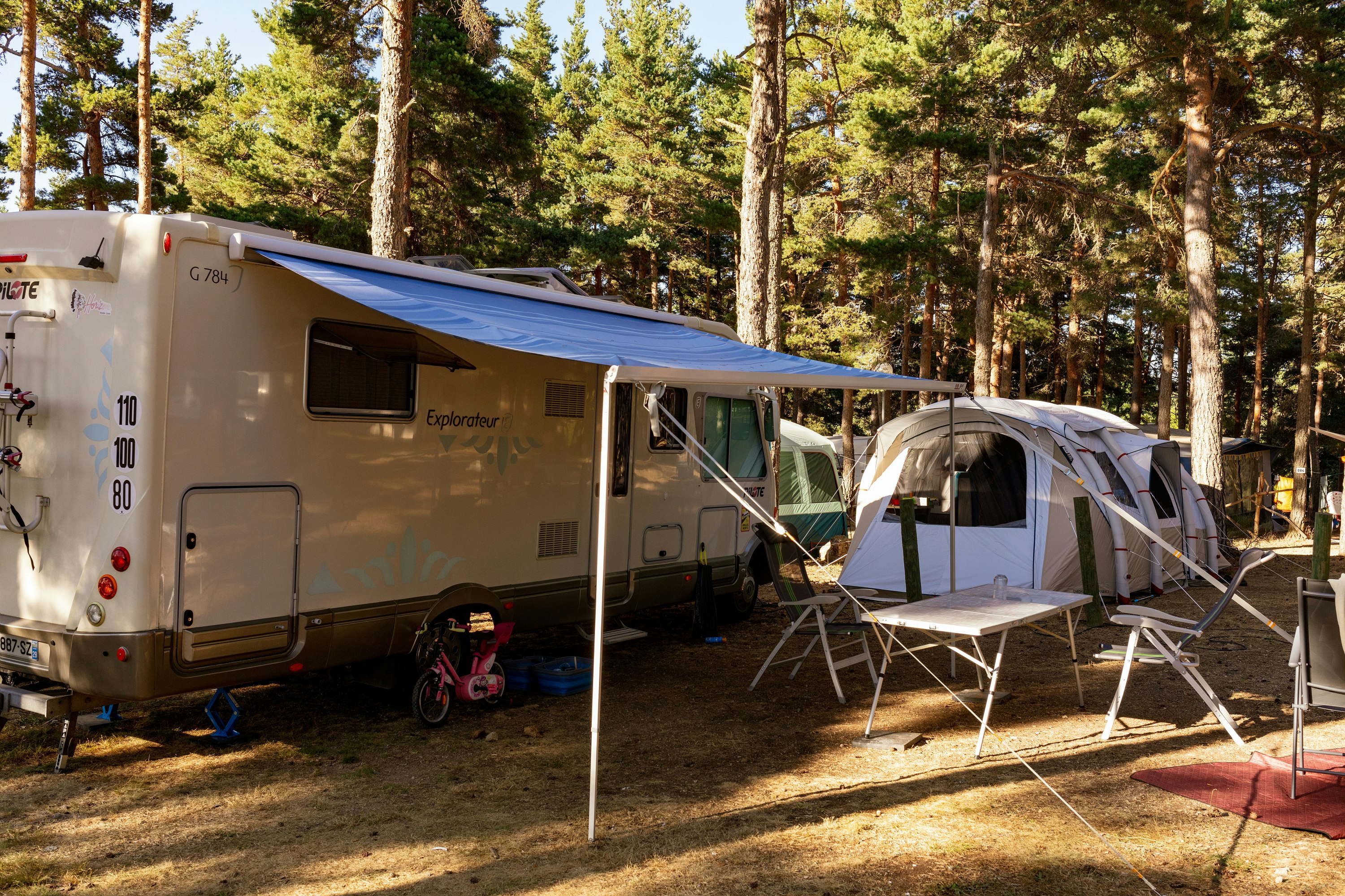 Camping Les Sous Bois du Lac - Stellplatz mit Wohnwagen auf dem Campingplatz