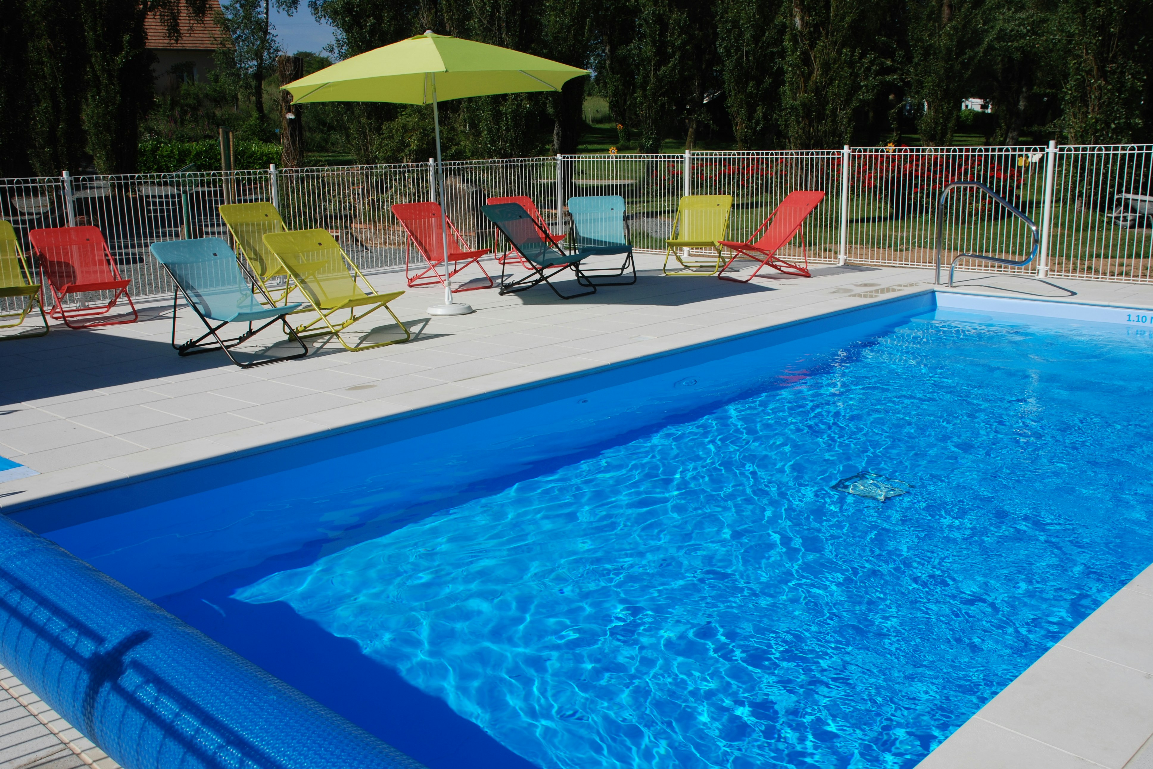 Camping Les Tournesols - Pool im Freien mit Liegestühlen und Sonnenschirmen