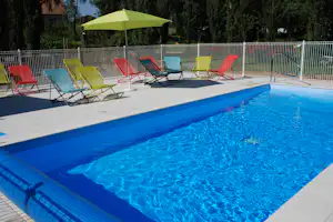 Camping Les Tournesols - Pool im Freien mit Liegestühlen und Sonnenschirmen