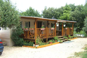 Camping Les Truffières - Mobilheim vom Campingplatz mit begrünter Veranda