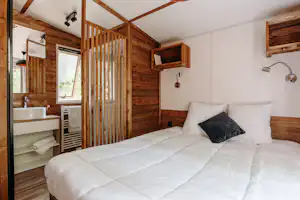 Slow Village Séveilles Camping Les Valades - Doppelbett im Schlafzimmer eines Mobilheims