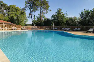 Camping L'Etang Blanc - Pool im Freien mit Liegestühlen und Sonnenschirmen