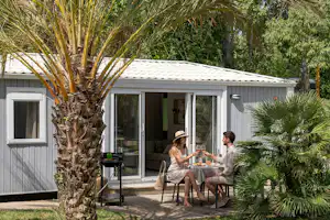 Camping L’Hippocampe - Camper sitzen am Tisch auf der Terrasse eines Mobilheims