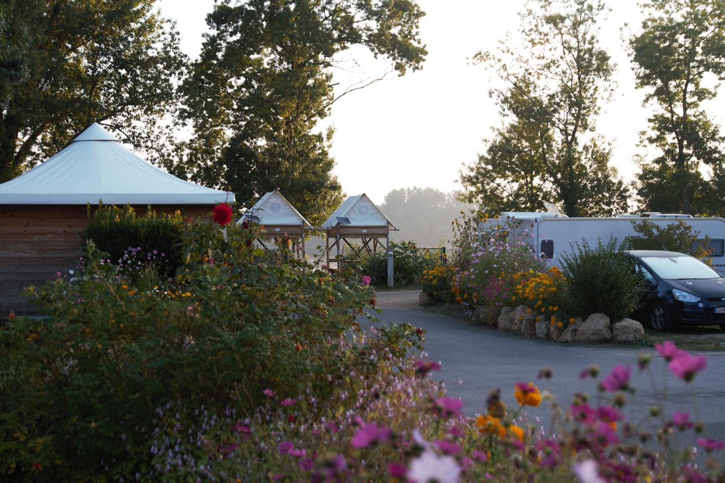 Camping L'Isle Verte - Zelte auf Stelzen auf dem Campingplatz mit Blumen