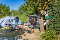 Camping L'Océan - Der Zeltplatz mit Zelten Esstisch und liegendem Hund im Grünen