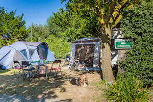 Camping L'Océan - Der Zeltplatz mit Zelten Esstisch und liegendem Hund im Grünen
