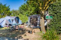 Camping L'Océan - Der Zeltplatz mit Zelten Esstisch und liegendem Hund im Grünen