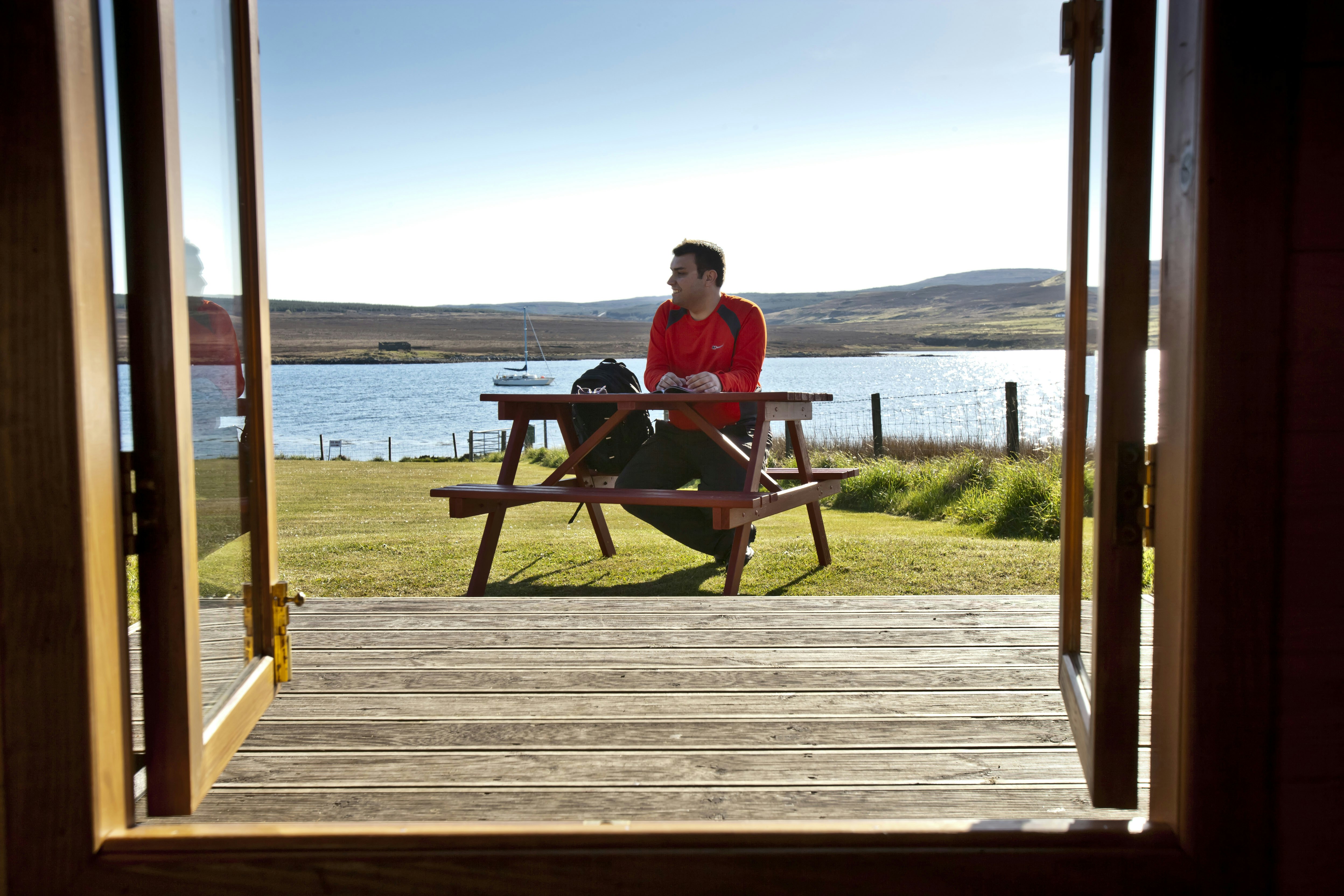 Camping Loch Greshornish Club Site  -  Camper am Picknicktisch vom Mobilheim auf dem Campingplatz mit Blick auf den Meeresarm