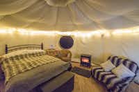 Camping Loch Greshornish Club Site  -  Innenansicht vom Mobilheim auf dem Campingplatz mit Bett, Sofa und Kamin