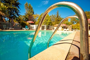 Camping L'Olivier - Pool im Freien mit Liegestühlen und Sonnenschirmen