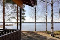 Camping Lomakylä Marjoniemi - Veranda einer Holzhütte auf dem Campingplatz mit Blick auf den See
