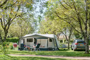 Camping Sandaya L'Orée du Bois - Camperpaar vor ihrem Wohnwagen in der Sonne