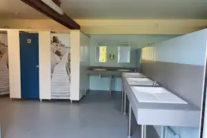 Camping L'Orée de Deauville - Sanitärgebäude mit Waschbecken, Spiegel, Toiletten und Duschen