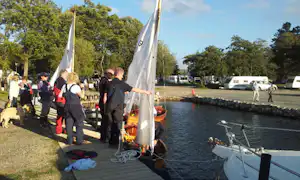 Camping Lough Ree - Holzboote im Wasser am Anleger des Campingplatzes mit Wohnwagen auf Stellplätzen im Hintergrund