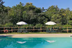 Camping Lucherino - Pool im Freien mit Liegestühlen und Sonnenschirmen