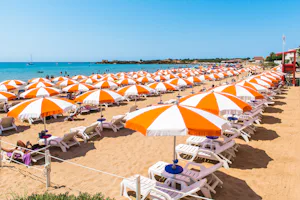 Camping Luminoso - Strand mit Liegen und Sonnenschirmen am Campingplatz