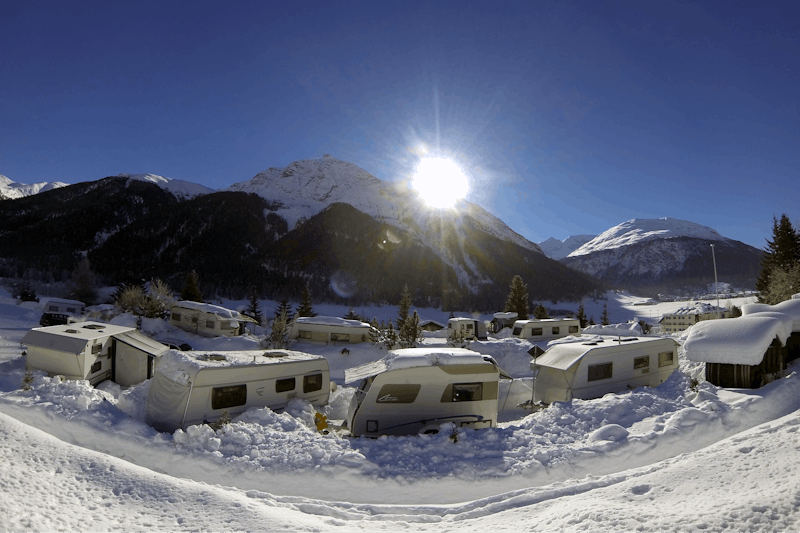 Camping Madulain - Wohnwagenstellplatz mit Blick auf Berge im Winter