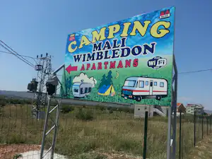 Großes Camping-Wandbanner mit Aufschrift „Camping Campi“ und „WimbleDon“ sowie „Free WiFi spot“ und Wohnwagen-Illustrationen.
