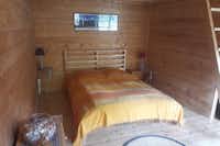 Camping Mandala - Innenansicht eines Mobilheims mit Doppelbett