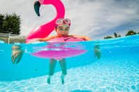 Camping Manoir de Ker An Poul - Kind schwimmt auf dem aufblasbaren Flamingo im Pool des Campingplatzes