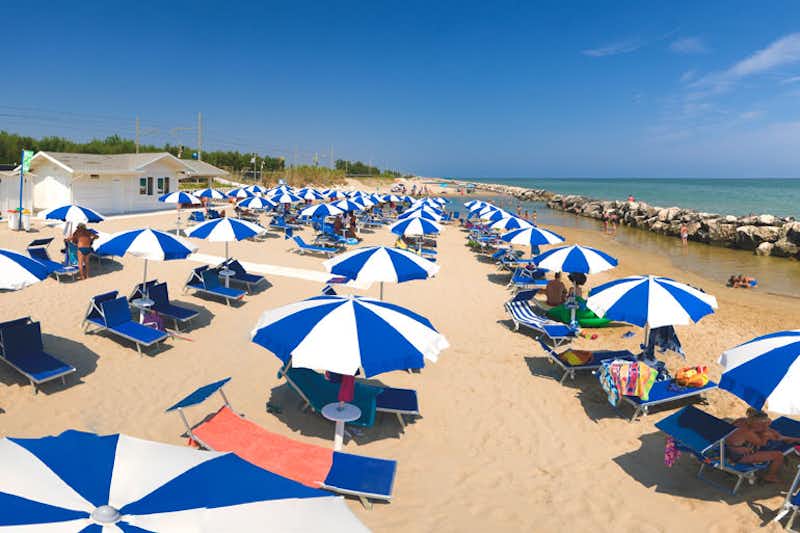 Camping Mareblu  -  Campingplatz am Strand vom Mittelmeer mit Sonnenschirmen und Liegestühlen