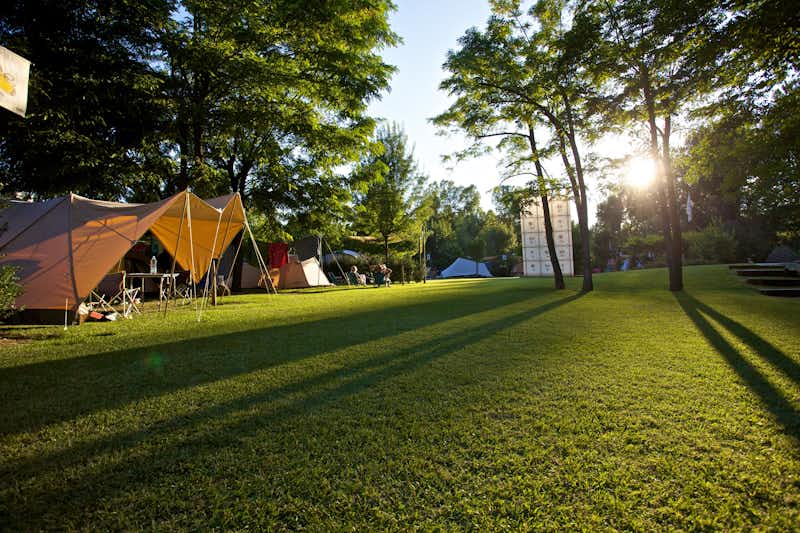 Camping Marecchia - Zeltwiese mit mehreren aufgestellten Zelten und sitzenden Campern
