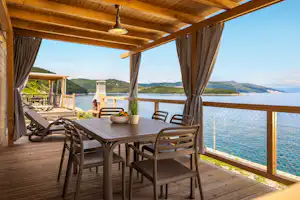 Camping Marina - Terrasse eines Mobilheims mit Vorhang und Meerblick