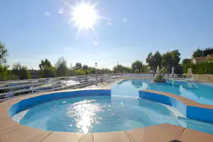 Camping Marino - Poolbereich vom Campingplatz mit Liegestühlen, Sonnenschirmen und Blick über den Wohnwagen- und Zeltstellplatz