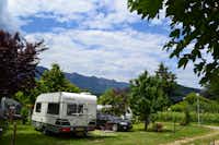 Camping Markushof  -  Wohnwagen- und Zeltstellplatz zwischen Bäumen mit Blick auf die Berge