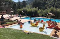 Camping Mas de Champel - Poolbereich mit Liegestühlen und Sonnenschirmen