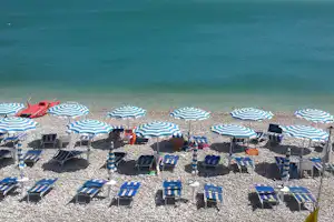 Camping Mattinata - Strand mit Liegestühlen und Sonnenschirmen am Campingplatz