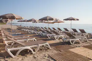 Camping Merendella - Liegestühle und Sonnenschirme am Strand