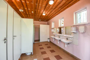 Camping Mindūnai - Innenansicht des Sanitärbereichs mit Waschbecken und Toilettenkabinen