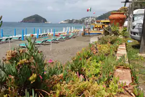 Camping Mirage - Der Strand des Mittelmeers mit Liegestühlen und Sonnenschirmen darauf direkt am Campingplatz
