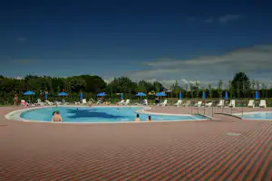 Camping Miramare - Poolbereich mit Liegestühlen und Sonnenschirmen am Rand