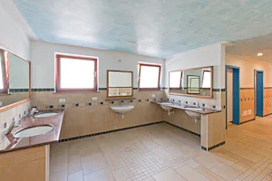 Camping Miravalle - Sanitärgebäude mit Waschbecken, Spiegel, Toiletten und Duschen