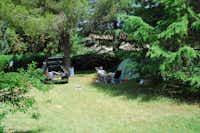 Camping Monti del Sole - Camper sitzt vor seinem Zelt zwischen Bäumen