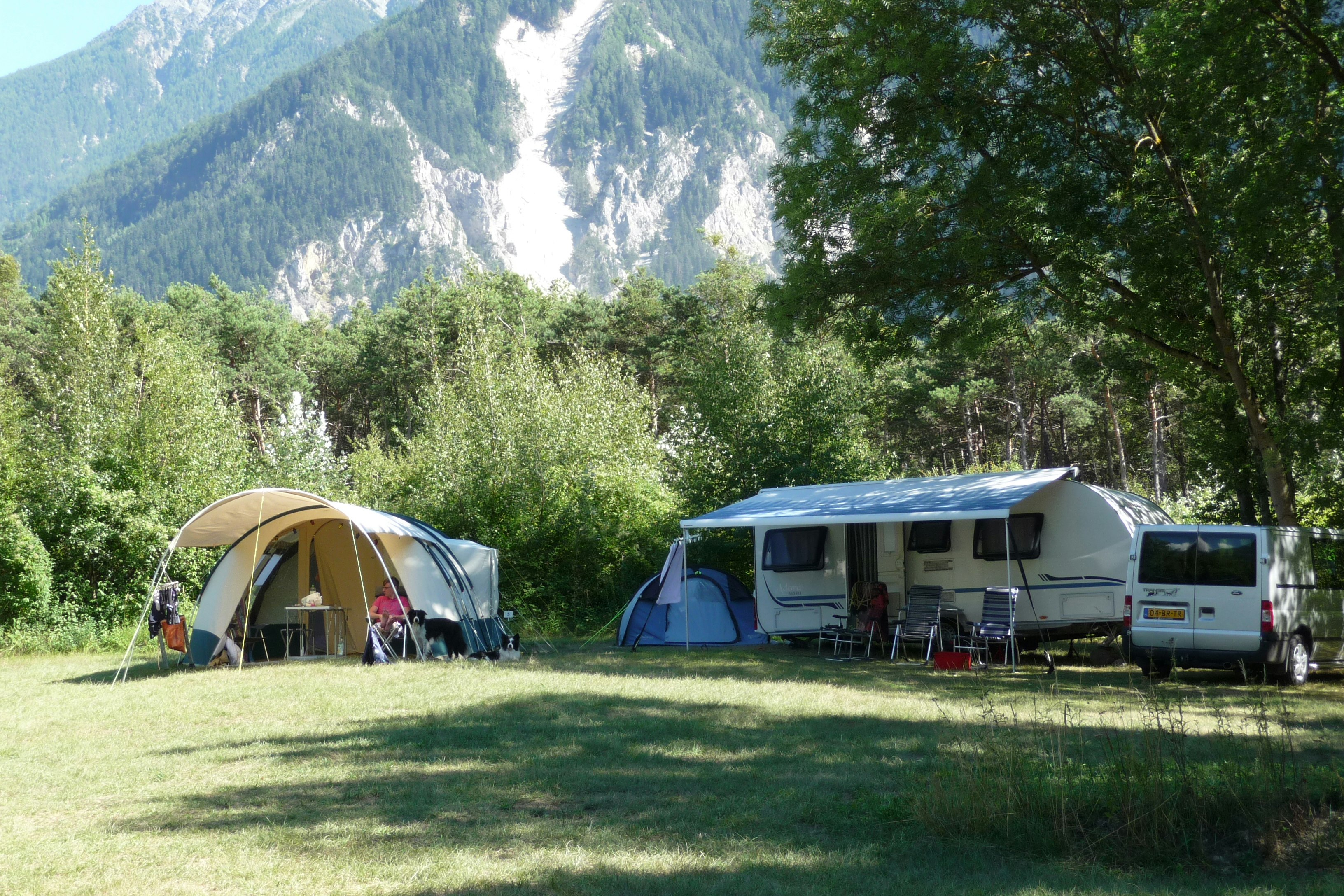 Camping Monument - Wohnwagen- und Zeltstellplatz zwischen Bäumen auf dem Campingplatz