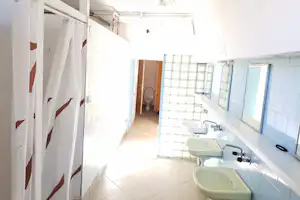 Camping-Motel Harenda nr. 160 - Innenansicht des Sanitärbereichs mit Waschbecken und Duschkabine