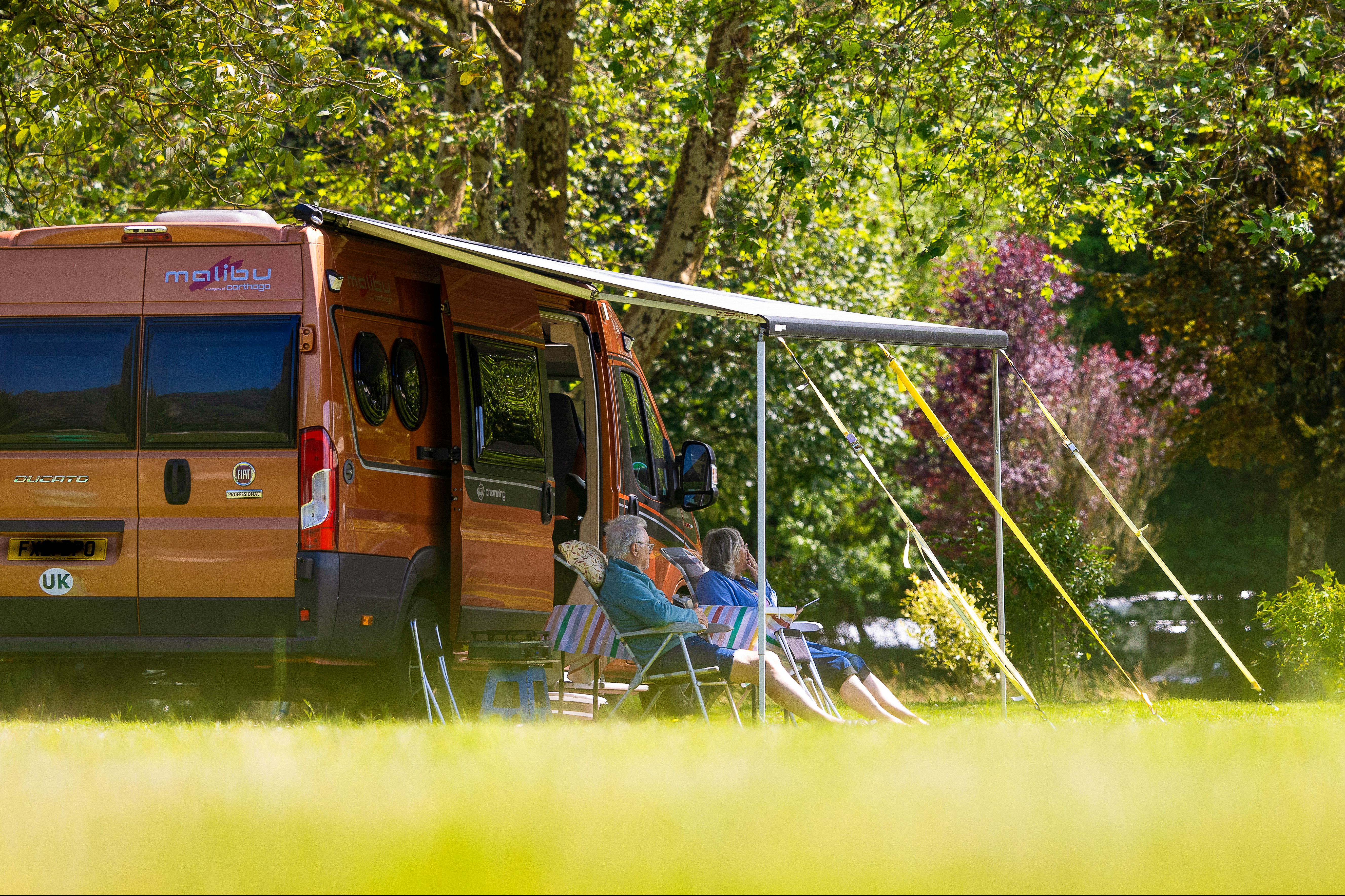 Camping Moulin du Bel Air - Camper entspannen vor ihrem Standplatz im Grünen
