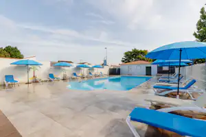 Camping Municipal de la Baie Camping Bel Air Village La Baie - Pool im Freien mit Liegestühlen und Sonnenschirmen
