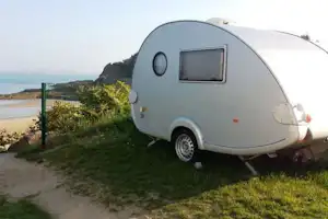 Camping Municipal du Port Blanc - Wohnwagen auf dem Stellplatz mit Blick auf den Strand vom Campingplatz
