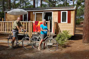 Camping La Grigne - Camper auf Fahrrädern vor einem Mobilheim vom Campingplatz